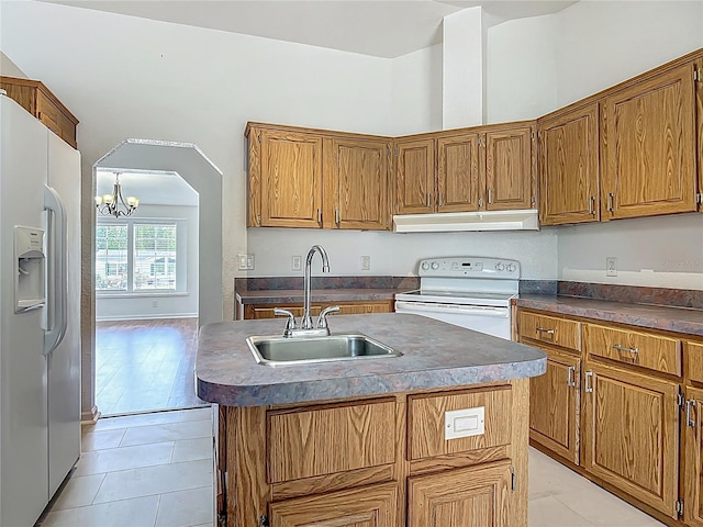 12352 SE 86th Ct, Belleview, FL 34420 - kitchen with white appliances, a sink, under cabinet range hood, light tile patterned floors, and dark countertops