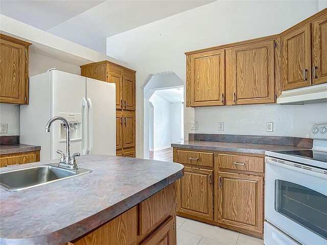 12352 SE 86th Ct, Belleview, FL 34420 - kitchen with white appliances, under cabinet range hood, a sink, and brown cabinetry