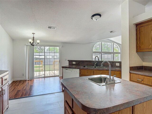 12352 SE 86th Ct, Belleview, FL 34420 - kitchen featuring dishwasher, a sink, plenty of natural light, a textured ceiling, and vaulted ceiling