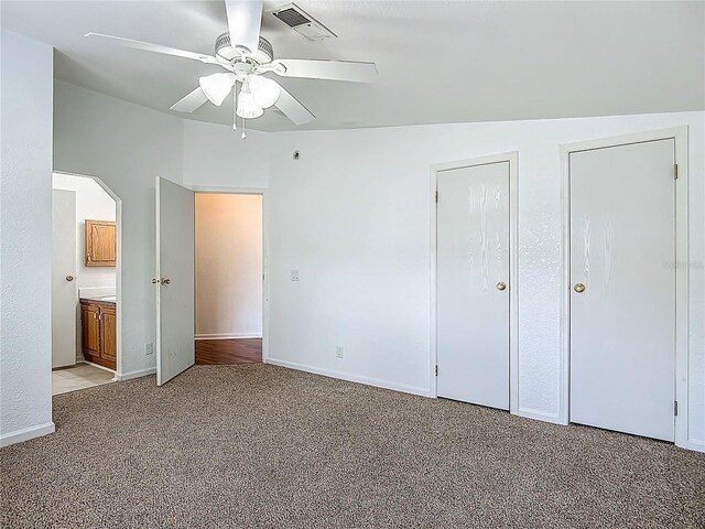 12352 SE 86th Ct, Belleview, FL 34420 - unfurnished bedroom with light carpet, ensuite bath, baseboards, and ceiling fan