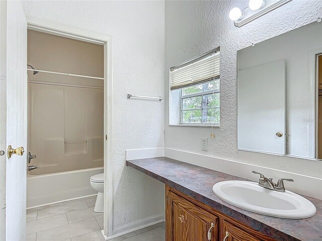 12352 SE 86th Ct, Belleview, FL 34420 - full bath featuring a textured wall, vanity, toilet, tile patterned floors, and washtub / shower combination