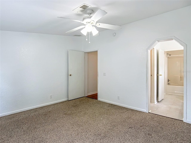 12352 SE 86th Ct, Belleview, FL 34420 - unfurnished bedroom featuring light carpet, arched walkways, baseboards, and ceiling fan