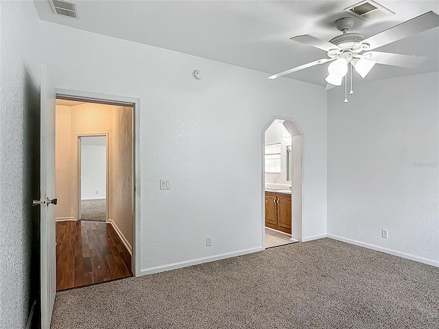 12352 SE 86th Ct, Belleview, FL 34420 - unfurnished bedroom featuring carpet flooring, arched walkways, baseboards, ensuite bathroom, and a textured wall