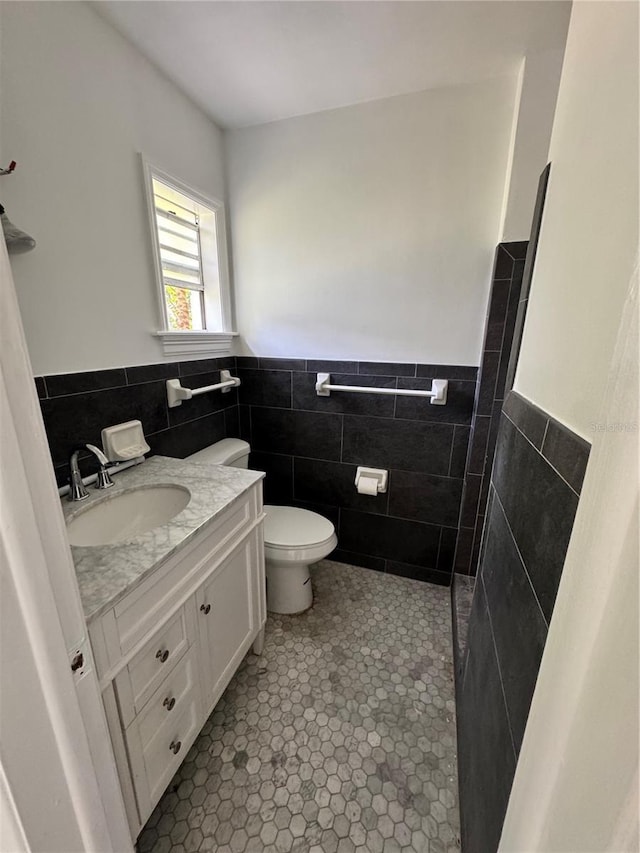 4000 SW 6th Ave, Ocala, FL 34471 - bathroom with tile walls, vanity, wainscoting, toilet, and tile patterned flooring