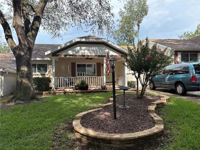 9801 SW 88th Ter Unit B, Ocala, FL 34481 - view of front of house with a porch, a front yard, brick siding, and a ceiling fan