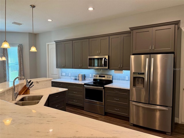 10208 SE 170th Pl, Summerfield, FL 34491 - kitchen with appliances with stainless steel finishes, a sink, tasteful backsplash, pendant lighting, and light stone counters