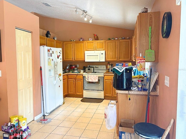 14 Dogwood Drive Radl, Ocala, FL 34472 - kitchen with white appliances, vaulted ceiling, light tile patterned floors, a textured ceiling, and light countertops