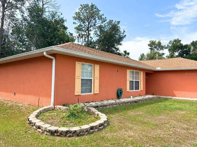 14 Dogwood Drive Radl, Ocala, FL 34472 - view of side of home featuring stucco siding and a yard