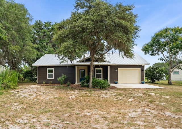 283 Riley Lake Dr, Hawthorne, FL 32640 - view of front facade with a garage, metal roof, a front lawn, and driveway