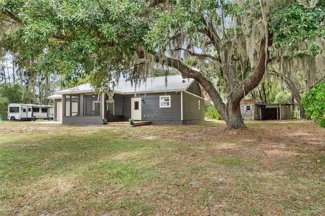 283 Riley Lake Dr, Hawthorne, FL 32640 - rear view of house featuring a sunroom, metal roof, and a lawn