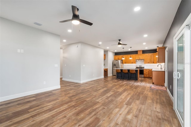 283 Riley Lake Dr, Hawthorne, FL 32640 - unfurnished living room with a ceiling fan, recessed lighting, light wood-style floors, baseboards, and a sink