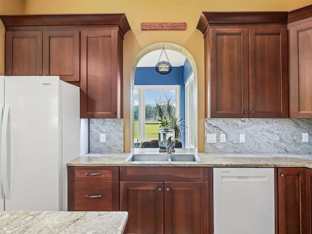 402 SW 127th Pl, Ocala, FL 34473 - kitchen with white appliances, a sink, decorative backsplash, and light stone counters