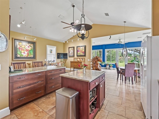 402 SW 127th Pl, Ocala, FL 34473 - kitchen with a ceiling fan, freestanding refrigerator, lofted ceiling, open floor plan, and light stone counters