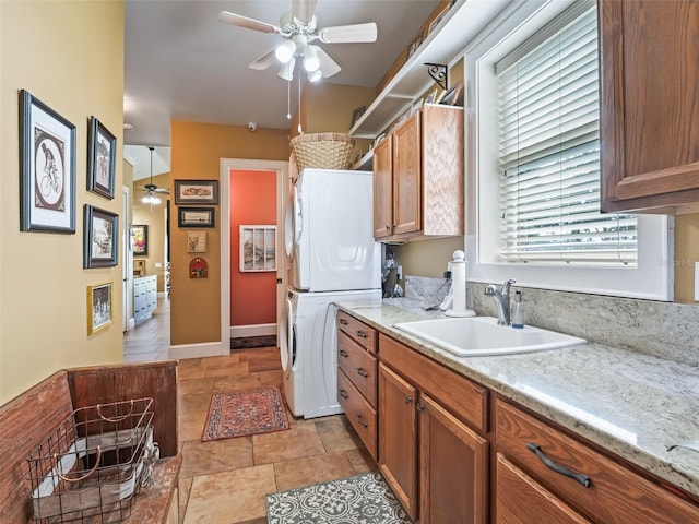 402 SW 127th Pl, Ocala, FL 34473 - laundry room with stacked washing machine and dryer, a ceiling fan, and stone finish floors
