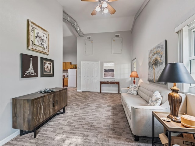 402 SW 127th Pl, Ocala, FL 34473 - living room with a ceiling fan, a high ceiling, light carpet, and baseboards