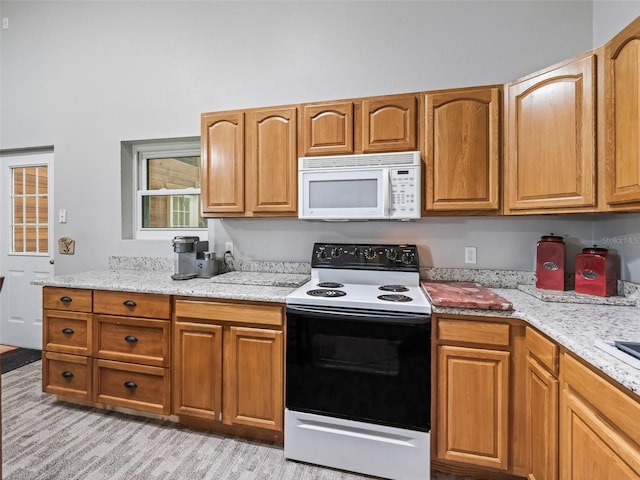 402 SW 127th Pl, Ocala, FL 34473 - kitchen featuring white microwave, electric range oven, light stone countertops, and brown cabinets