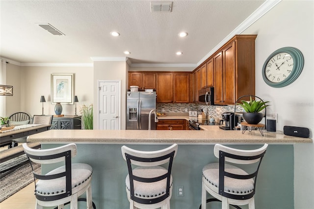 7263 SW 99th Cir, Ocala, FL 34481 - kitchen with appliances with stainless steel finishes, recessed lighting, light countertops, crown molding, and a peninsula