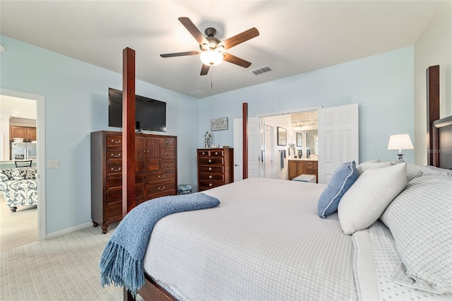 7263 SW 99th Cir, Ocala, FL 34481 - bedroom featuring stainless steel refrigerator with ice dispenser, light colored carpet, a ceiling fan, baseboards, and ensuite bath
