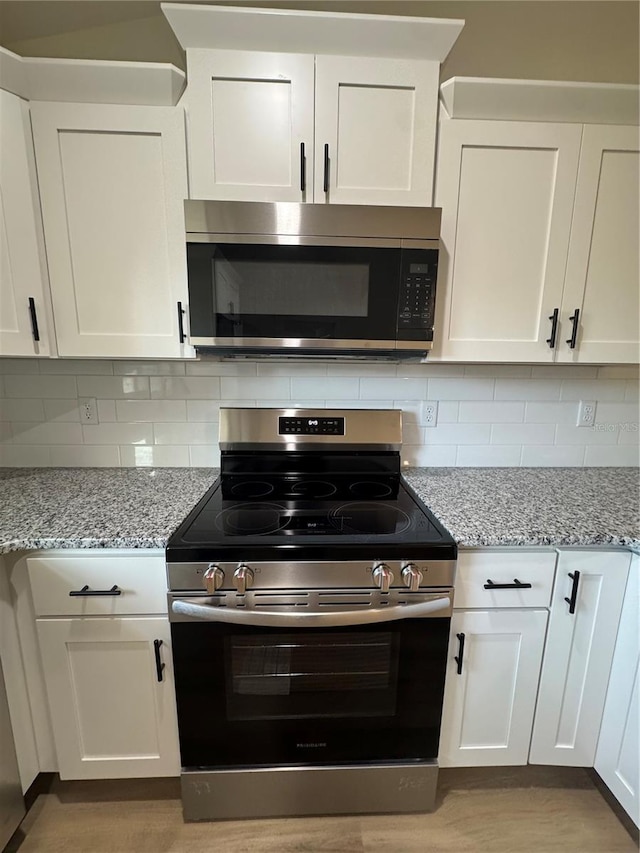 14425 SW 21st Pl, Ocala, FL 34481 - kitchen featuring stainless steel appliances, white cabinets, and light stone countertops