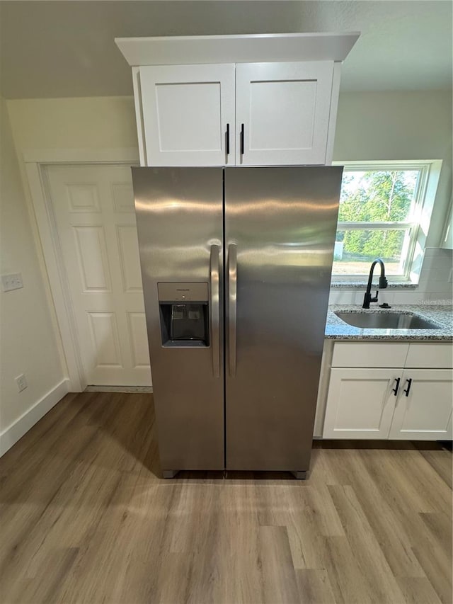 14425 SW 21st Pl, Ocala, FL 34481 - kitchen with stainless steel fridge, a sink, light wood-type flooring, and white cabinets