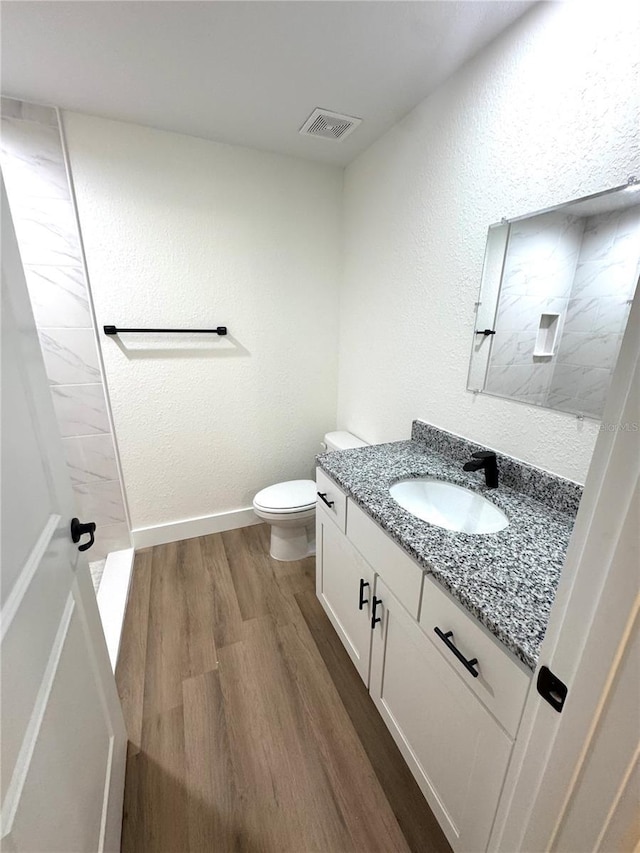 14425 SW 21st Pl, Ocala, FL 34481 - full bath with vanity, wood finished floors, toilet, a tile shower, and baseboards