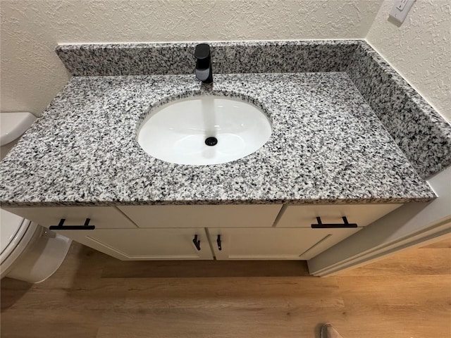 14425 SW 21st Pl, Ocala, FL 34481 - bathroom with toilet, wood finished floors, a sink, and a textured wall