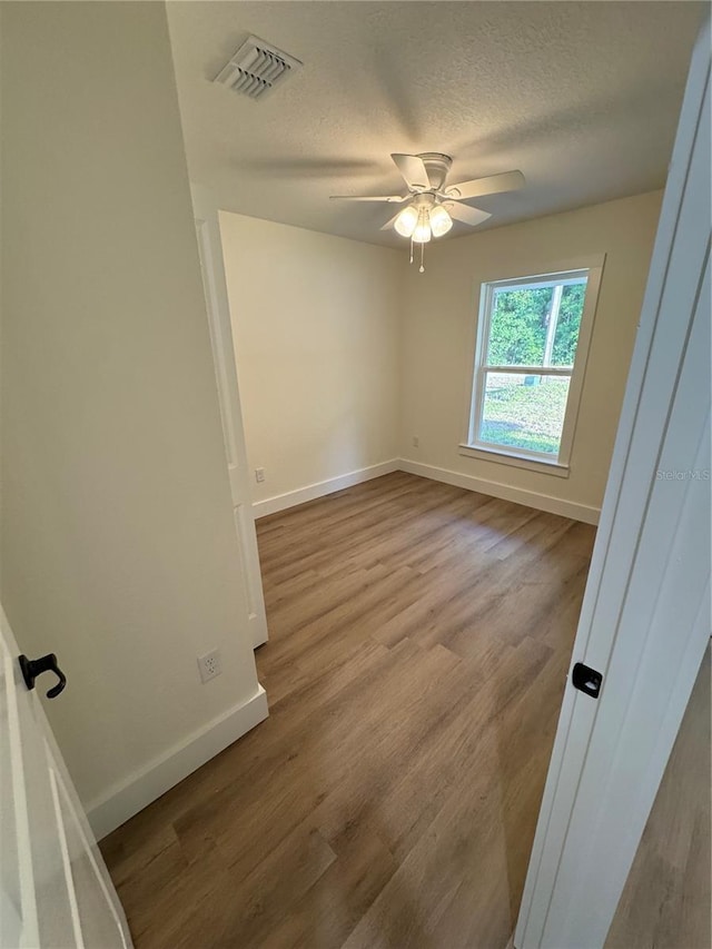 14425 SW 21st Pl, Ocala, FL 34481 - spare room with baseboards, a ceiling fan, wood finished floors, and a textured ceiling