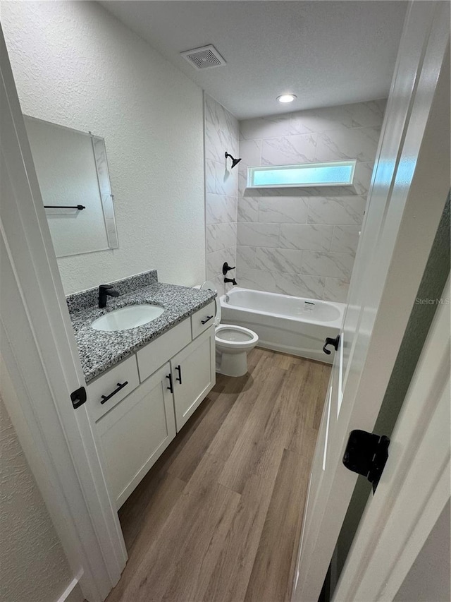 14425 SW 21st Pl, Ocala, FL 34481 - full bathroom featuring vanity,  shower combination, toilet, wood finished floors, and a textured wall