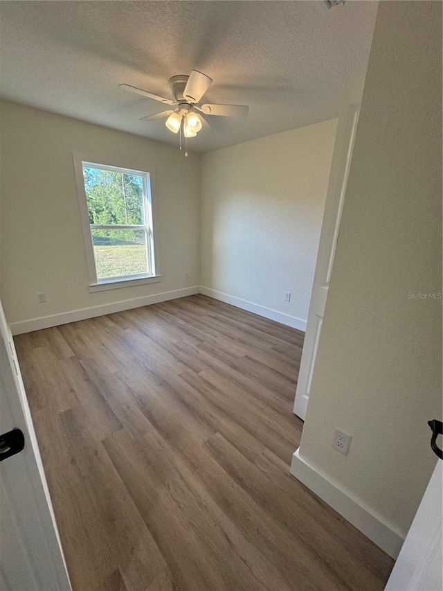 14425 SW 21st Pl, Ocala, FL 34481 - empty room featuring wood finished floors, a ceiling fan, a textured ceiling, and baseboards