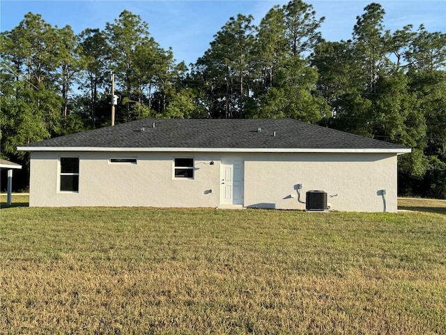14425 SW 21st Pl, Ocala, FL 34481 - back of property featuring a lawn, cooling unit, stucco siding, and view of scattered trees