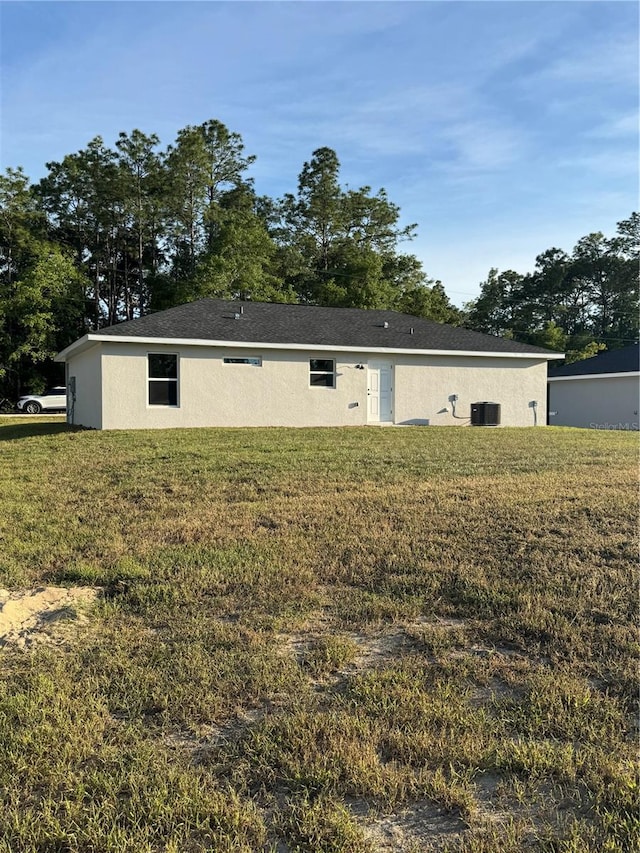 14425 SW 21st Pl, Ocala, FL 34481 - rear view of house featuring a yard, stucco siding, and central AC unit