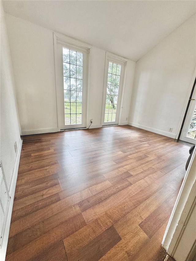 3005 NE 19th Ave, Ocala, FL 34479 - empty room with wood finished floors, vaulted ceiling, and baseboards