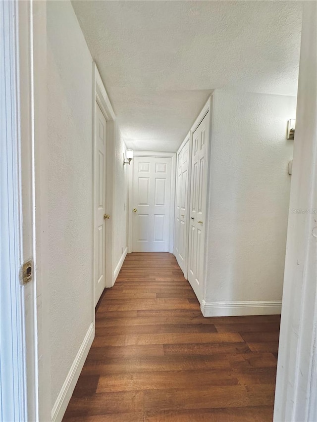 3005 NE 19th Ave, Ocala, FL 34479 - corridor featuring baseboards, dark wood-style floors, a textured ceiling, and a textured wall