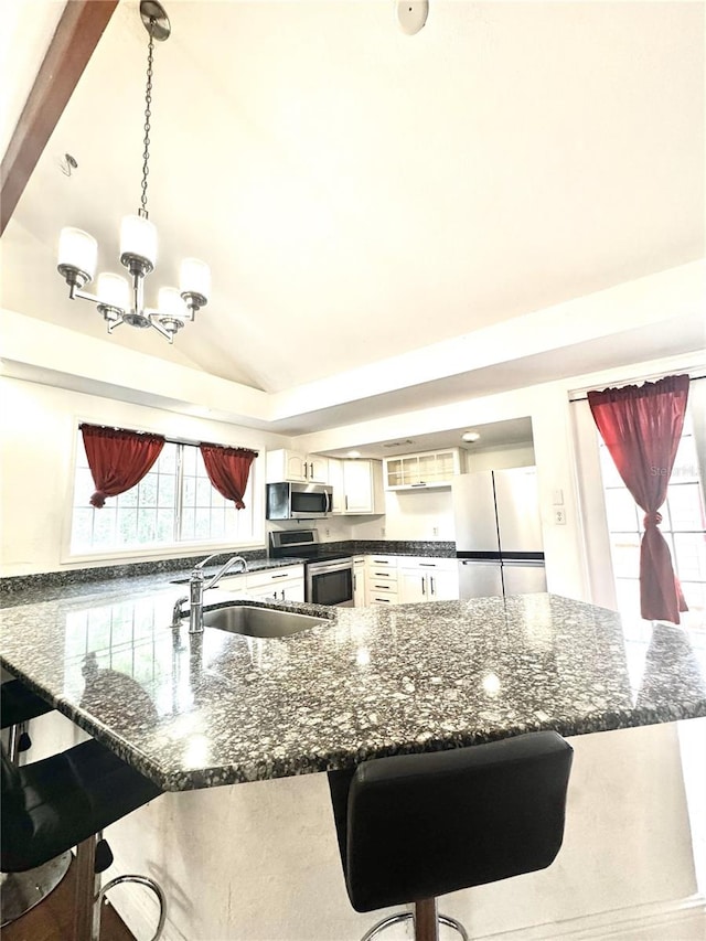 3005 NE 19th Ave, Ocala, FL 34479 - kitchen with stainless steel appliances, a sink, a kitchen bar, lofted ceiling, and a chandelier