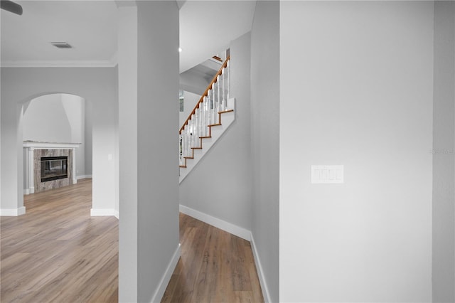 1628 SE 29th Ter, Ocala, FL 34471 - stairway with ornamental molding, baseboards, wood finished floors, arched walkways, and a high end fireplace