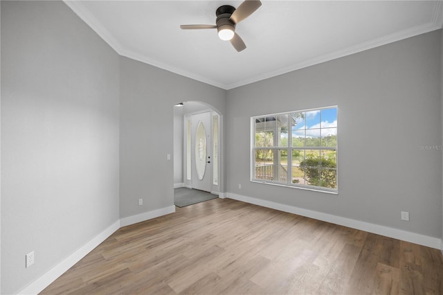1628 SE 29th Ter, Ocala, FL 34471 - spare room featuring arched walkways, crown molding, wood finished floors, a ceiling fan, and baseboards