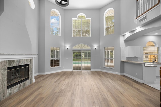 1628 SE 29th Ter, Ocala, FL 34471 - unfurnished living room with light wood-style flooring, a sink, healthy amount of natural light, and a high ceiling