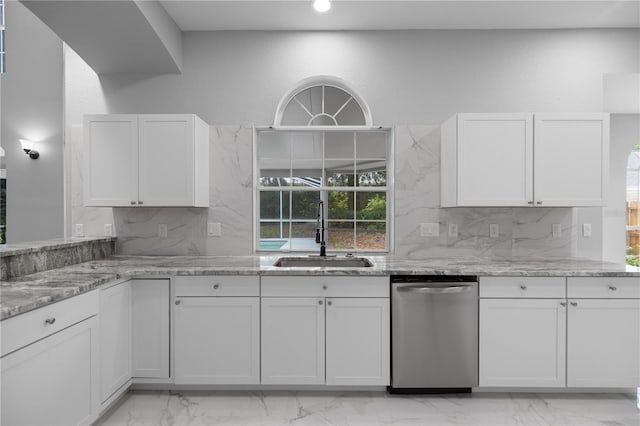 1628 SE 29th Ter, Ocala, FL 34471 - kitchen with dishwasher, a sink, light marble finish floors, white cabinetry, and tasteful backsplash