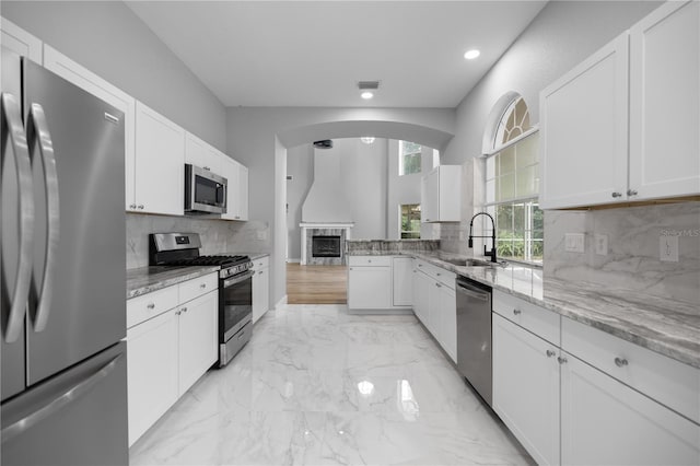 1628 SE 29th Ter, Ocala, FL 34471 - kitchen featuring stainless steel appliances, a sink, a fireplace, light stone counters, and recessed lighting