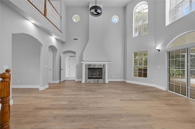 1628 SE 29th Ter, Ocala, FL 34471 - unfurnished living room featuring a towering ceiling, plenty of natural light, wood finished floors, and baseboards