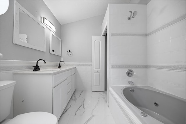 1628 SE 29th Ter, Ocala, FL 34471 - bathroom featuring marble look tiles, toilet, tile walls, vanity, and a wainscoted wall
