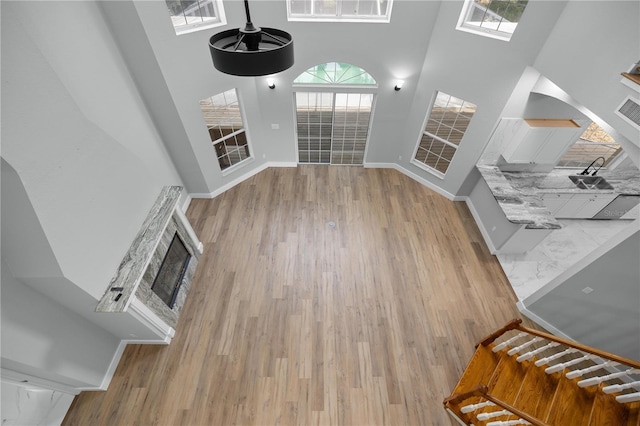 1628 SE 29th Ter, Ocala, FL 34471 - unfurnished living room with a towering ceiling, baseboards, wood finished floors, and a fireplace