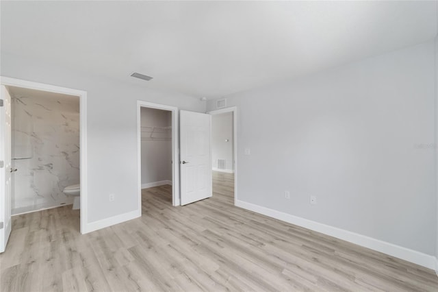 15424 SW 27th Ln, Ocala, FL 34481 - unfurnished bedroom with wood finished floors, a closet, baseboards, and a spacious closet