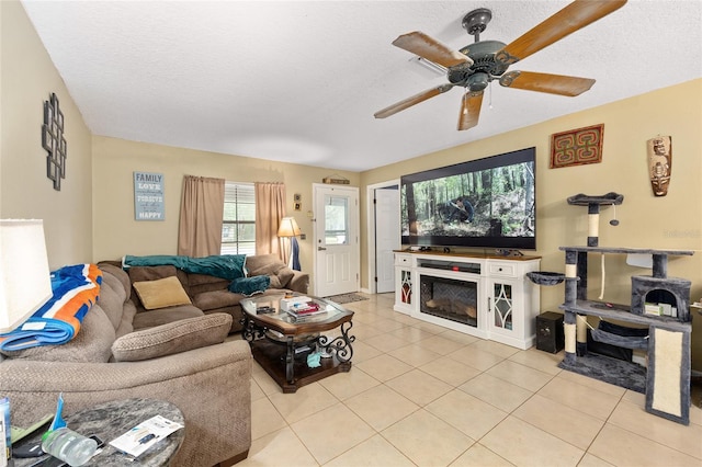 3800 NE 24th Ct, Ocala, FL 34479 - living room with ceiling fan, light tile patterned flooring, a textured ceiling, a glass covered fireplace, and baseboards