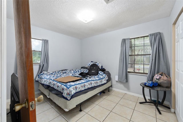3800 NE 24th Ct, Ocala, FL 34479 - bedroom with multiple windows, a textured ceiling, light tile patterned floors, and baseboards