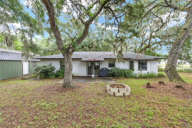 3800 NE 24th Ct, Ocala, FL 34479 - back of property with an outdoor fire pit, an outdoor structure, stucco siding, and a yard