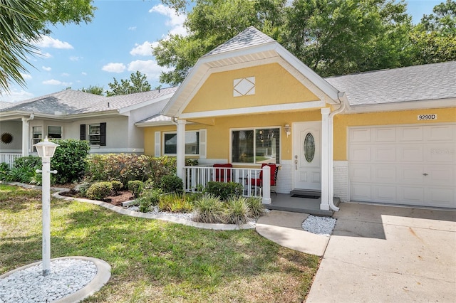9290 SW 89th Ter Unit D, Ocala, FL 34481 - view of front of home with covered porch, an attached garage, stucco siding, a front lawn, and concrete driveway