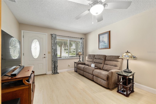 9290 SW 89th Ter Unit D, Ocala, FL 34481 - living room with light wood-style floors, a textured ceiling, baseboards, and ceiling fan