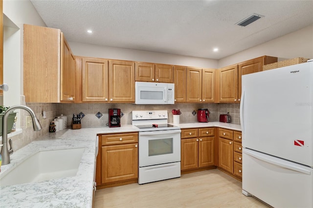 9290 SW 89th Ter Unit D, Ocala, FL 34481 - kitchen with white appliances, a sink, tasteful backsplash, light wood-type flooring, and recessed lighting