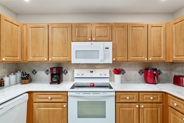 9290 SW 89th Ter Unit D, Ocala, FL 34481 - kitchen with white appliances, tasteful backsplash, and light countertops